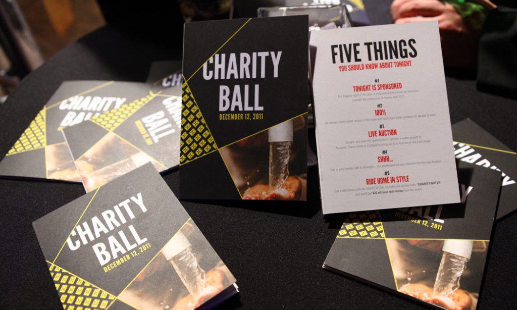 Charity: ball printed programs and a "Five things you should know about tonight" card on a dark table
