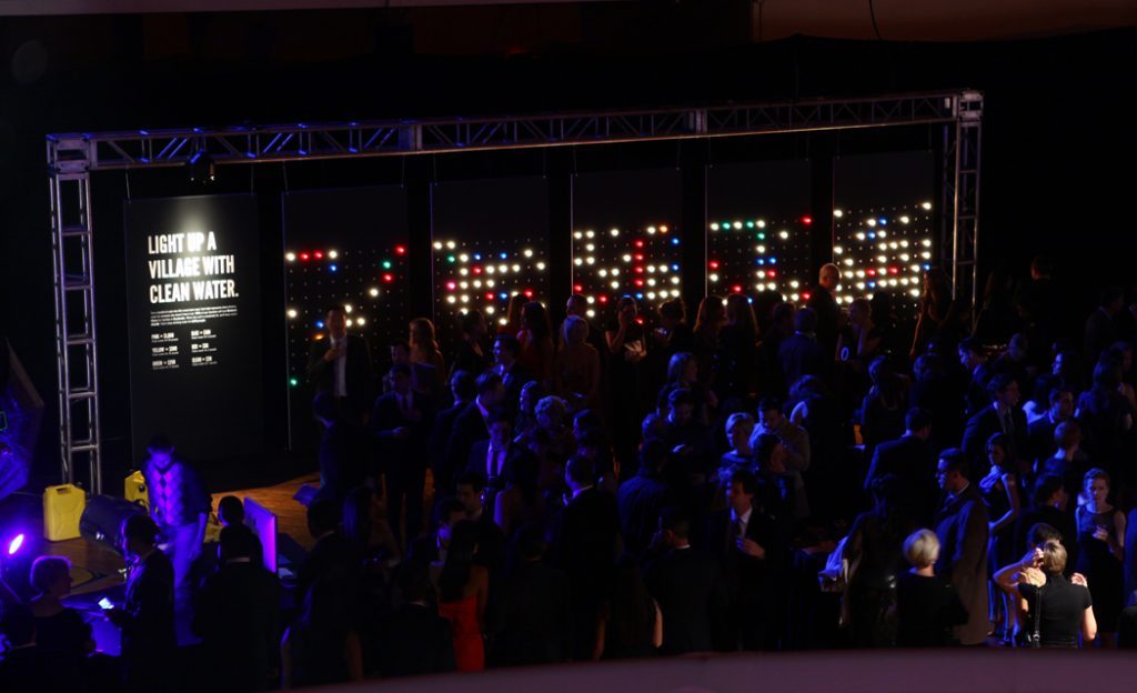 Crowd gathered in front of the wall of lights at the gala