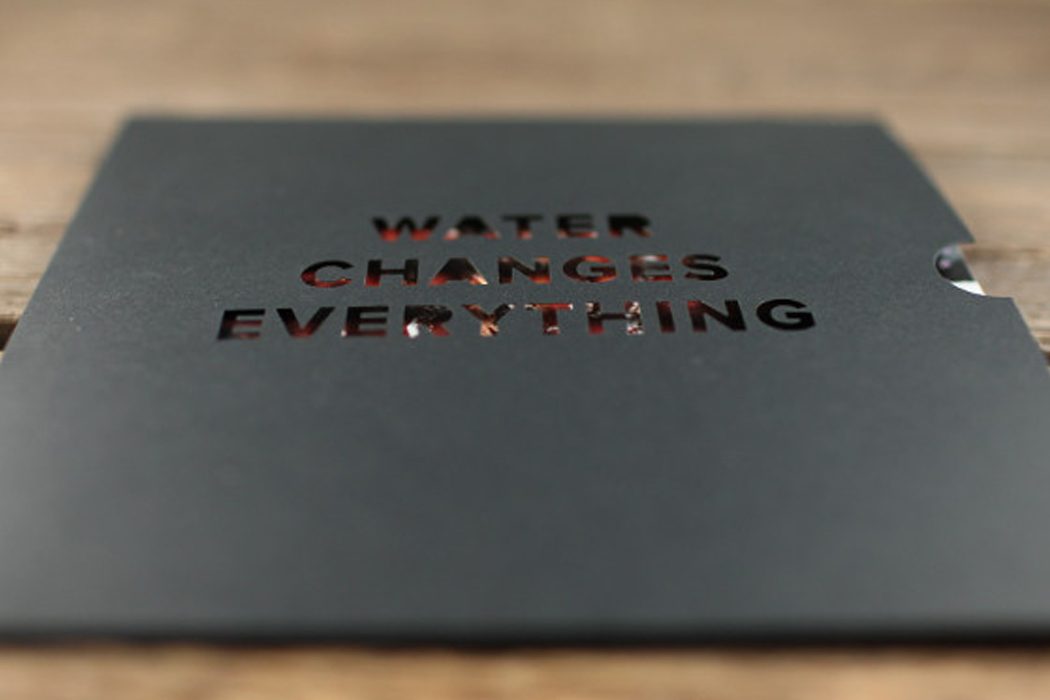 Black die-cut folder with the words "Water changes everything"