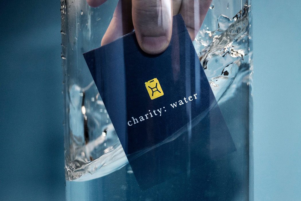 Navy charity: water card dropped into a glass of water
